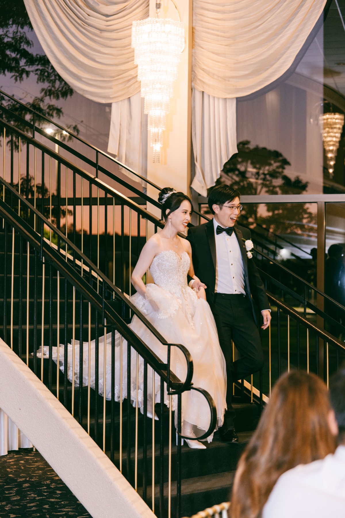 A newlywed couple descending a staircase together