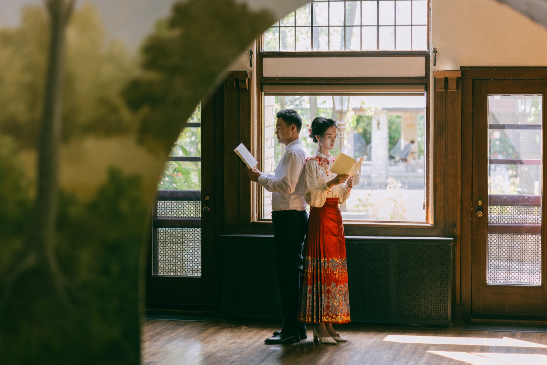 A couple reading letters together in traditional wedding attire