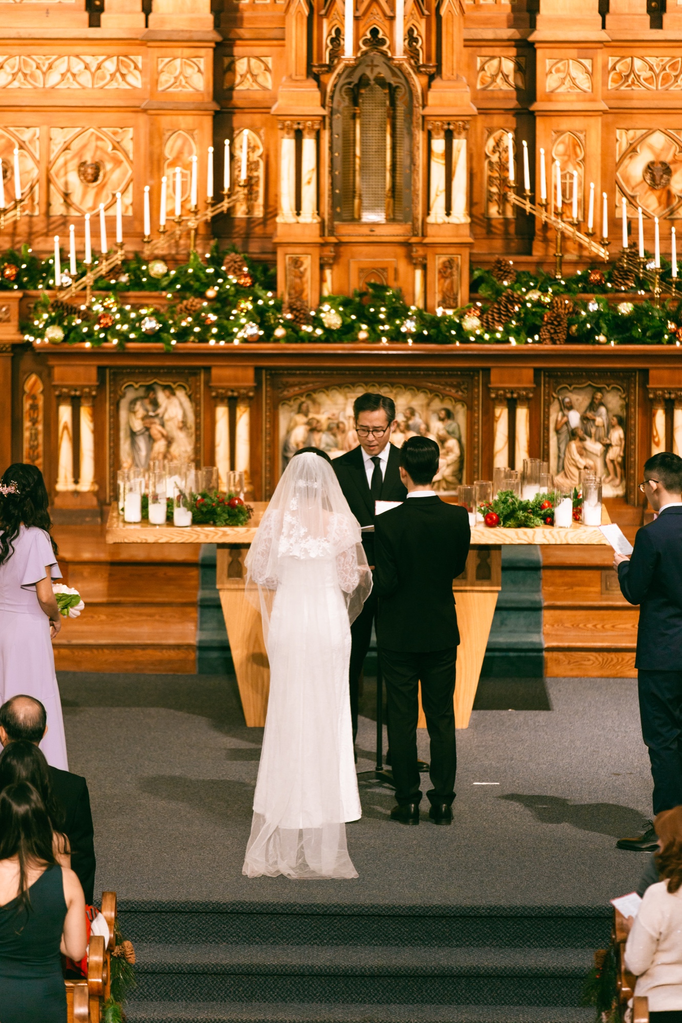 A wedding ceremony before a candlelit altar