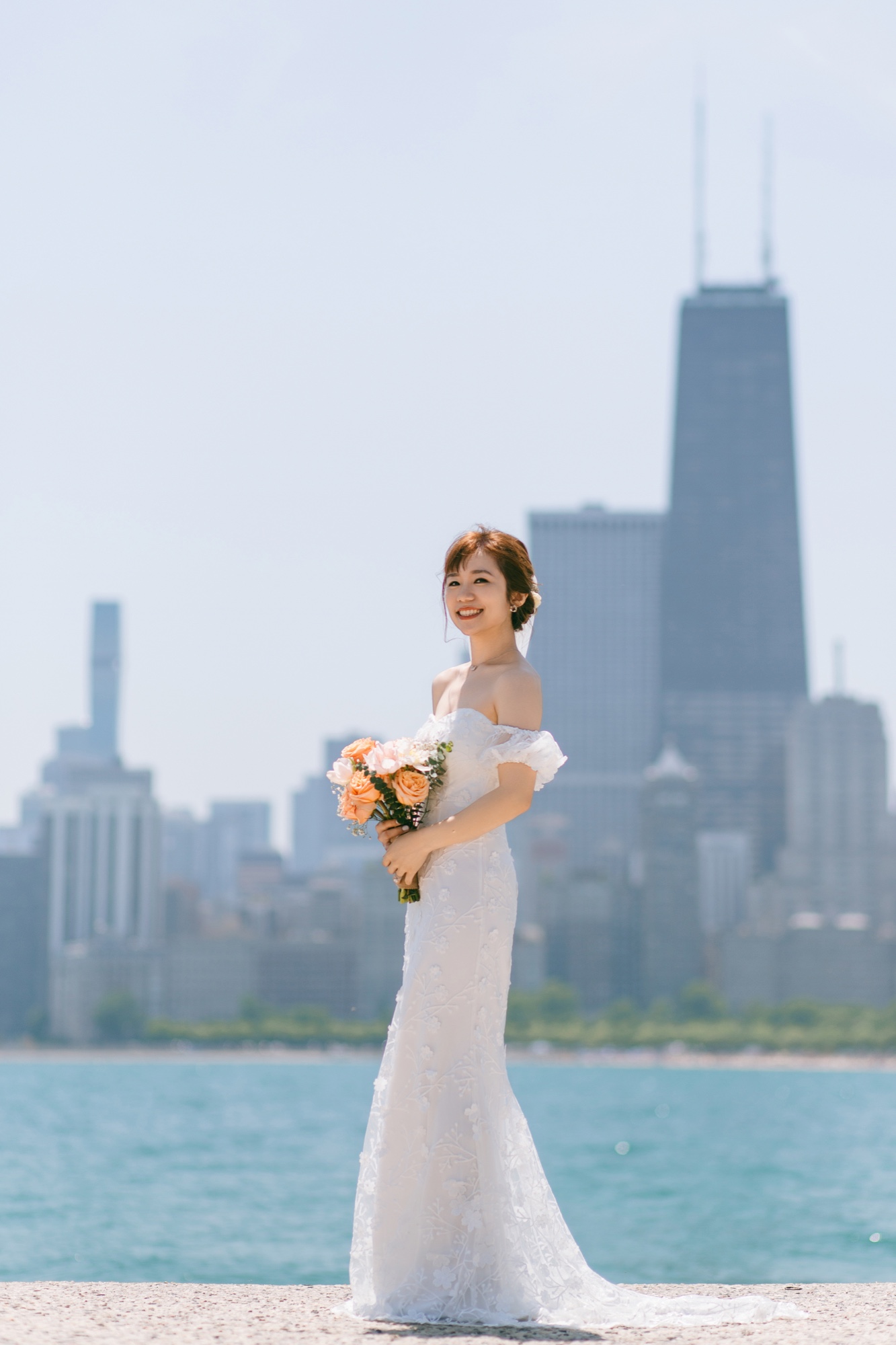 A bride holding a bouquet beside the Chicago lakefront skyline