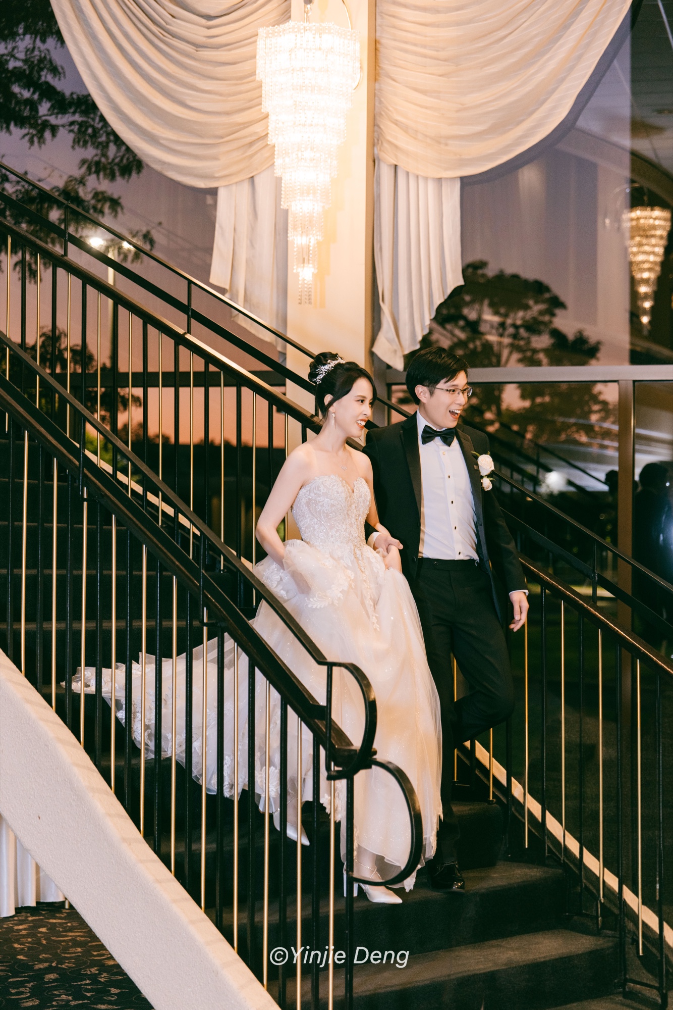 Newlyweds descending an indoor staircase