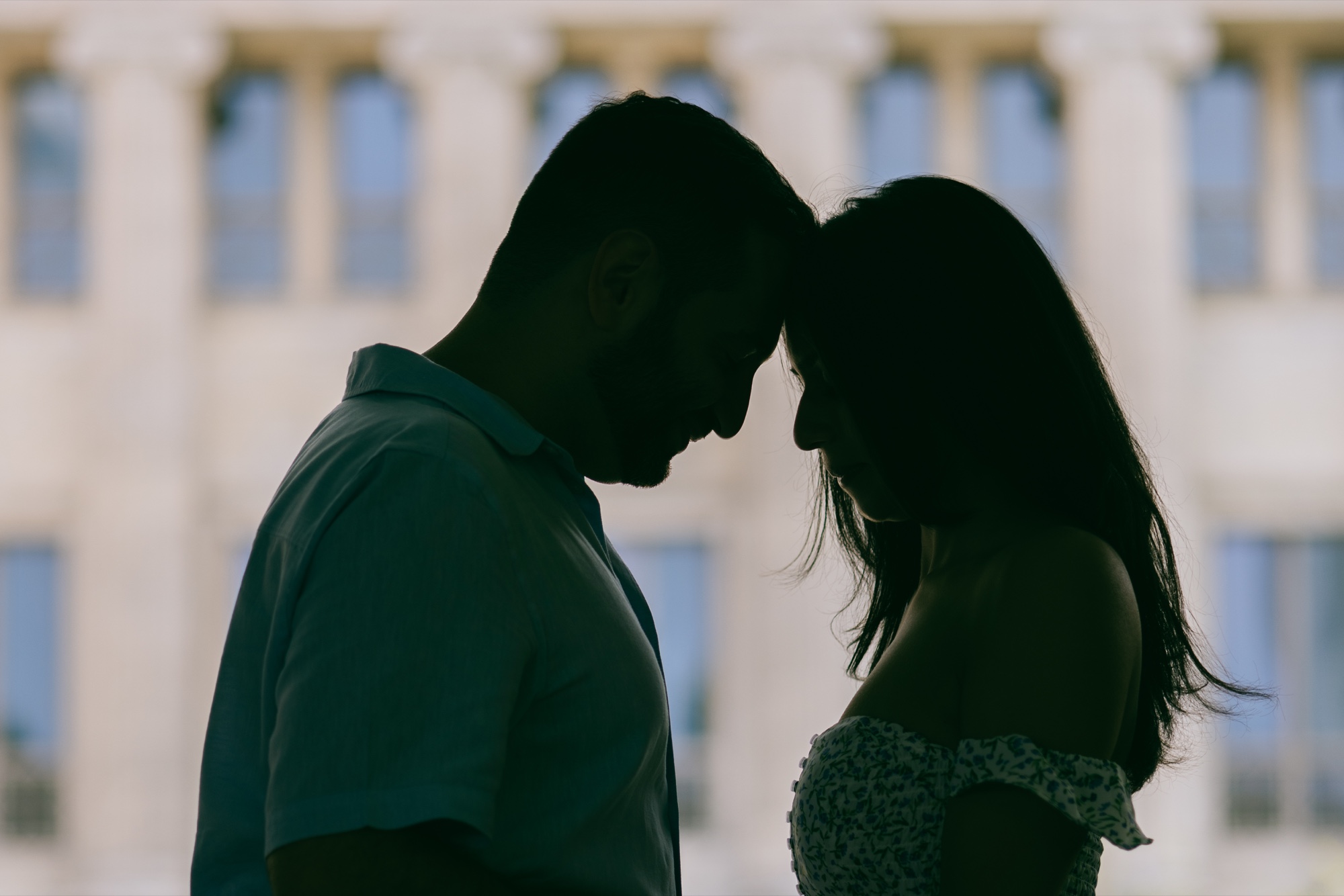 A silhouetted couple touching foreheads
